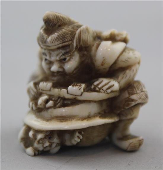 A Japanese walrus ivory netsuke of Shoki crushing two oni, signed Gyokuzan, Meiji period, 3.8cm